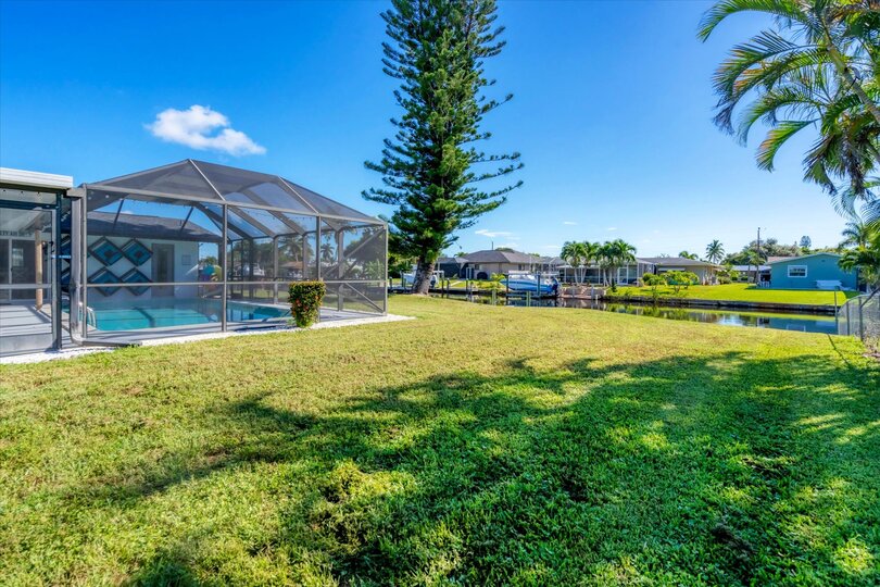 Large backyard leading to dock and canal