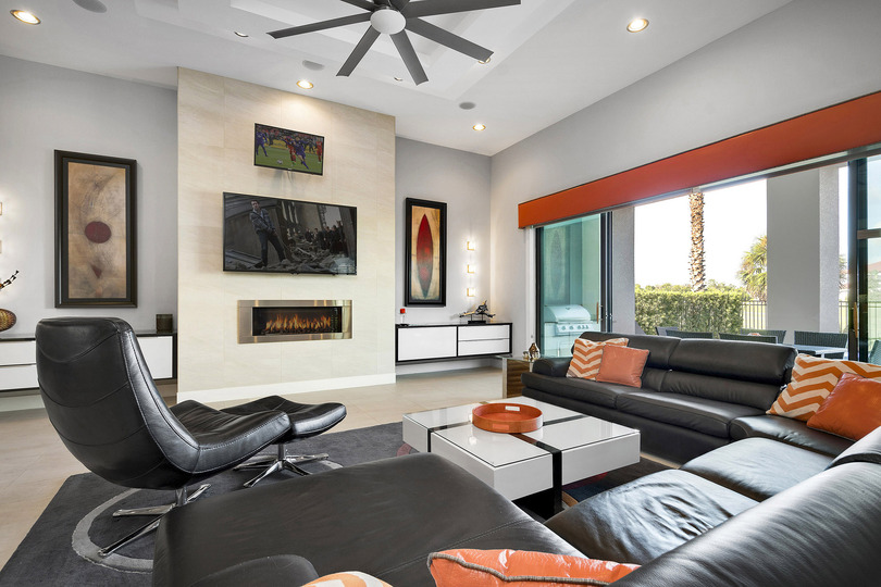 The living area features a 65-inch TV and 32-inch TV