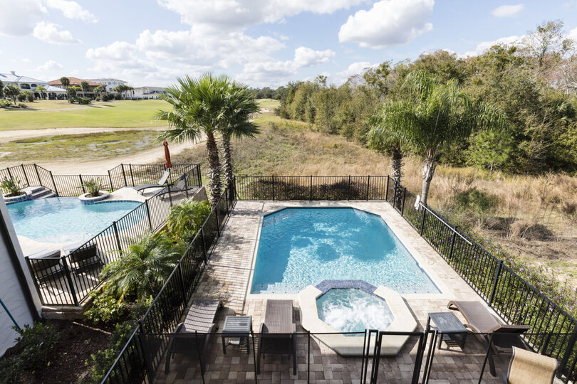 The master suite features its own private balcony with views to the golf course, conservation area, and pool
