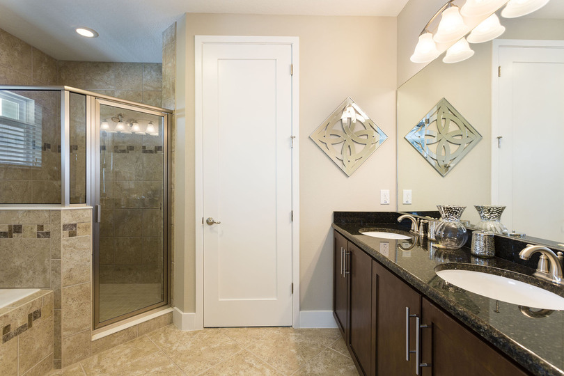 An en-suite bathroom with walk-in shower, dual vanity, and garden tub