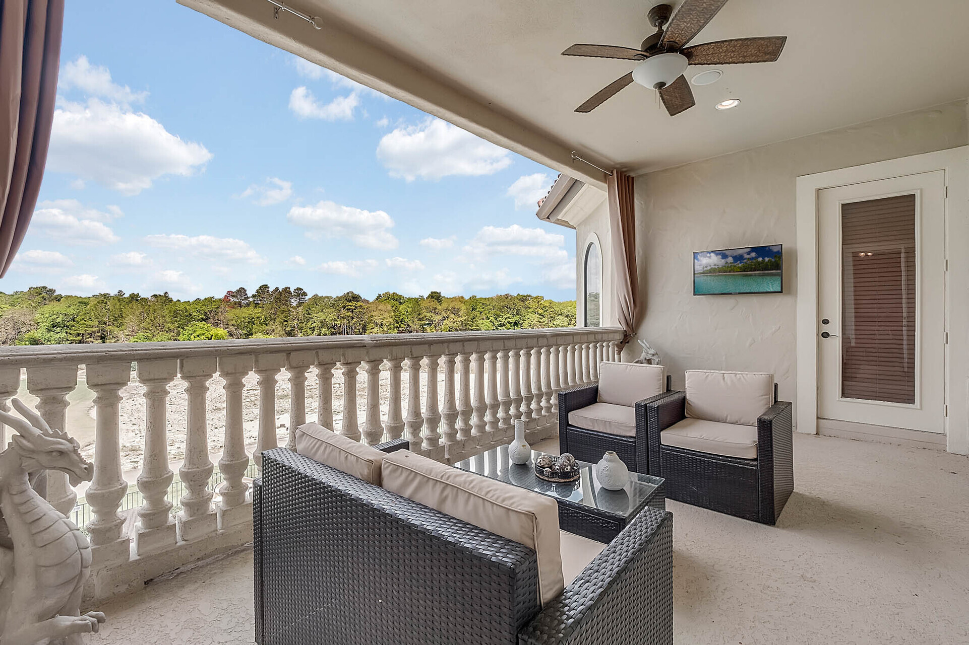 Upstairs balcony with comfortable seating and an outdoor TV