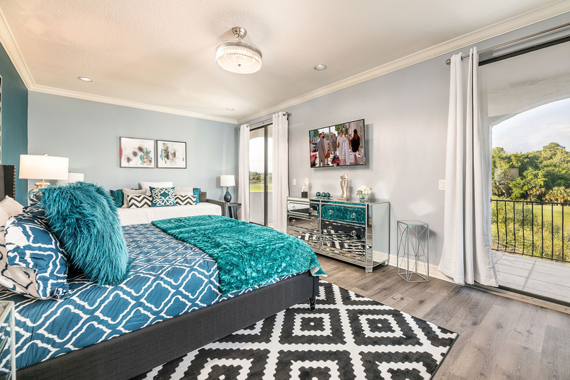 This second-floor master suite with a king-sized bed offers a private balcony with golf course views