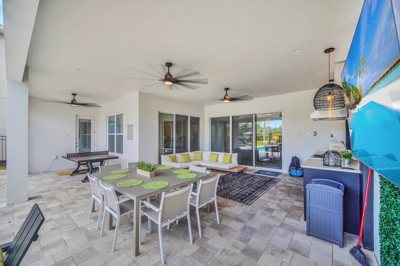 Dine al fresco under the covered lanai. The pool safety fence provides an added layer of protection