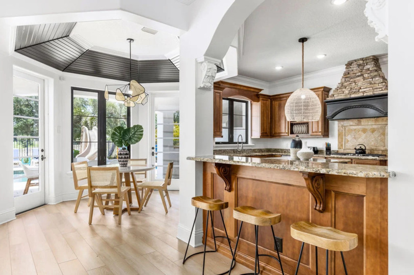 A three-seat breakfast bar provides a casual spot to grab a bite, while the formal dining table accommodates up to eight for sit-down meals.