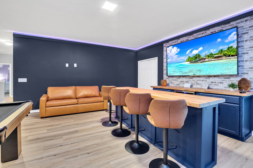 Watch your favorite sport on the 86" smart TV above the wet bar