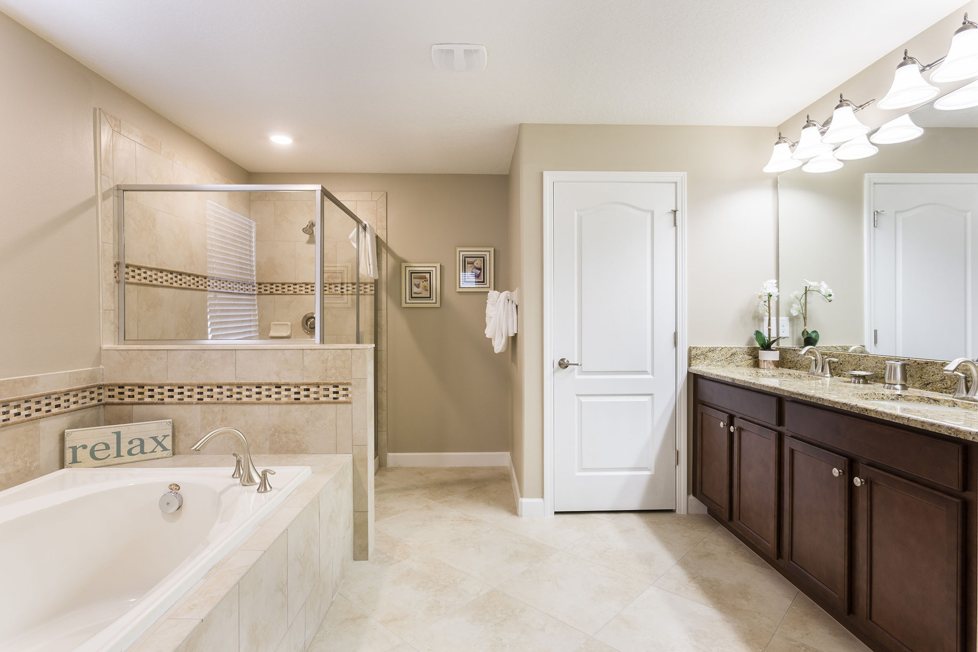 The ensuite bathroom has ample space with a glass shower and soaking tub