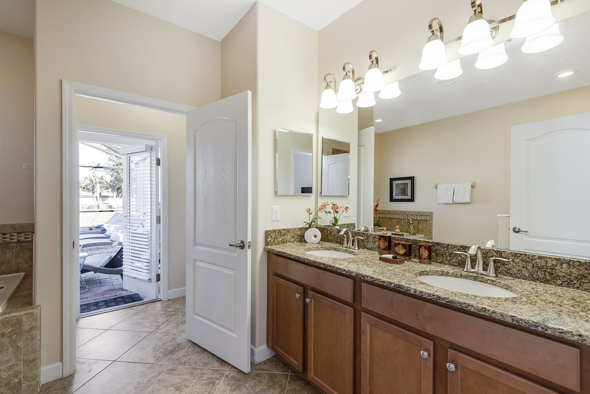The bathroom has access to the back patio and pool area