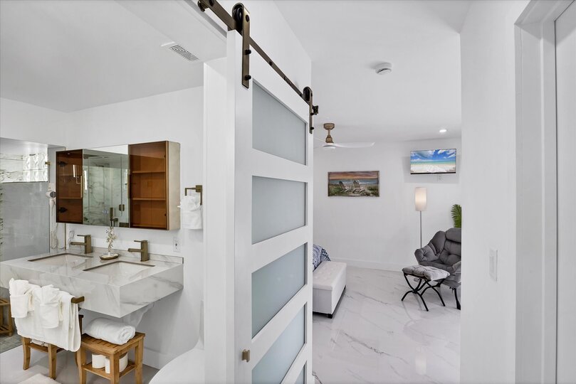 Double suite attached bathroom with walk-in shower, soaking tub, and double vanities