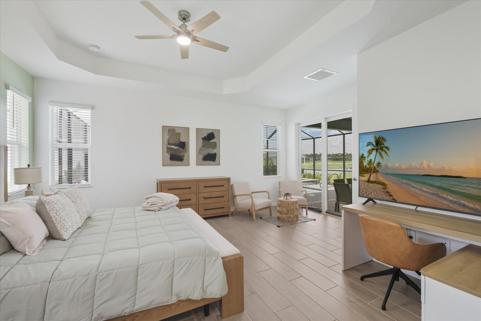Primary bedroom with king bed, attached bathroom, lanai access, and 65-inch Smart TV