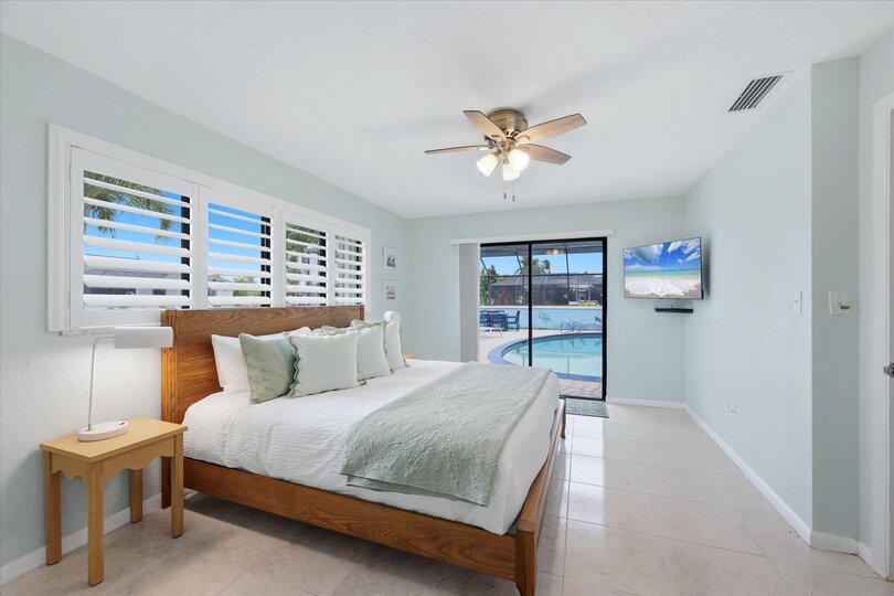 Bedroom 2 with king bed, attached bathroom, lanai access, and 43-inch Smart TV