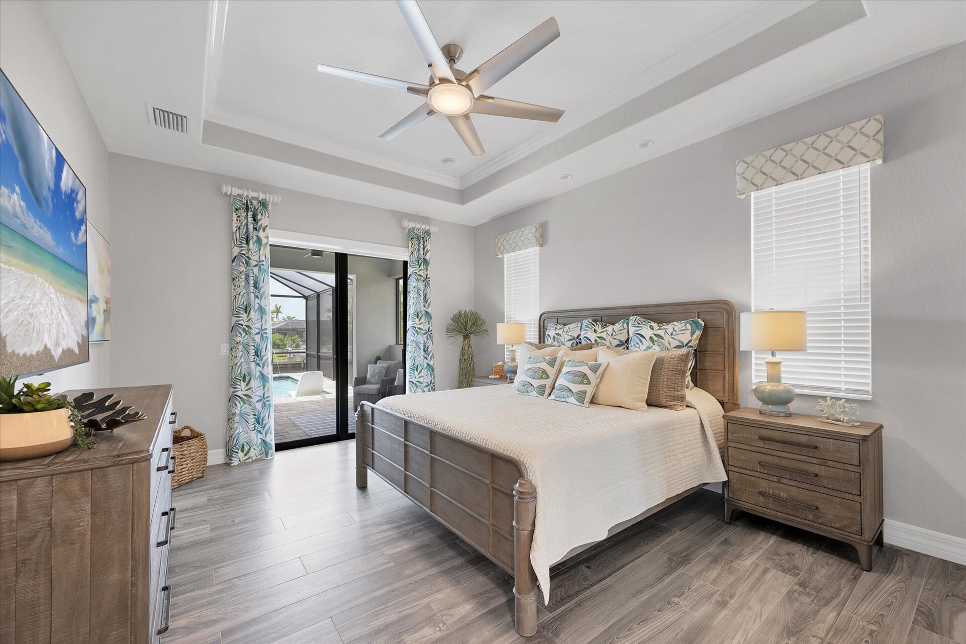 Beautiful primary bedroom with king bed, attached bathroom, lanai access and 75-inch Smart TV
