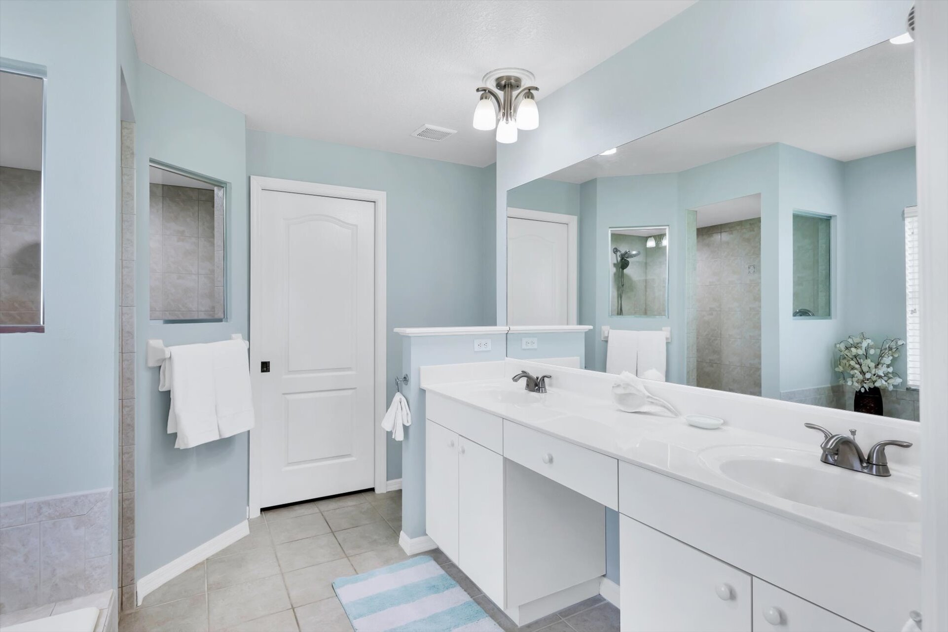 Primary ensuite with walk-in shower, soaking tub, and double vanities