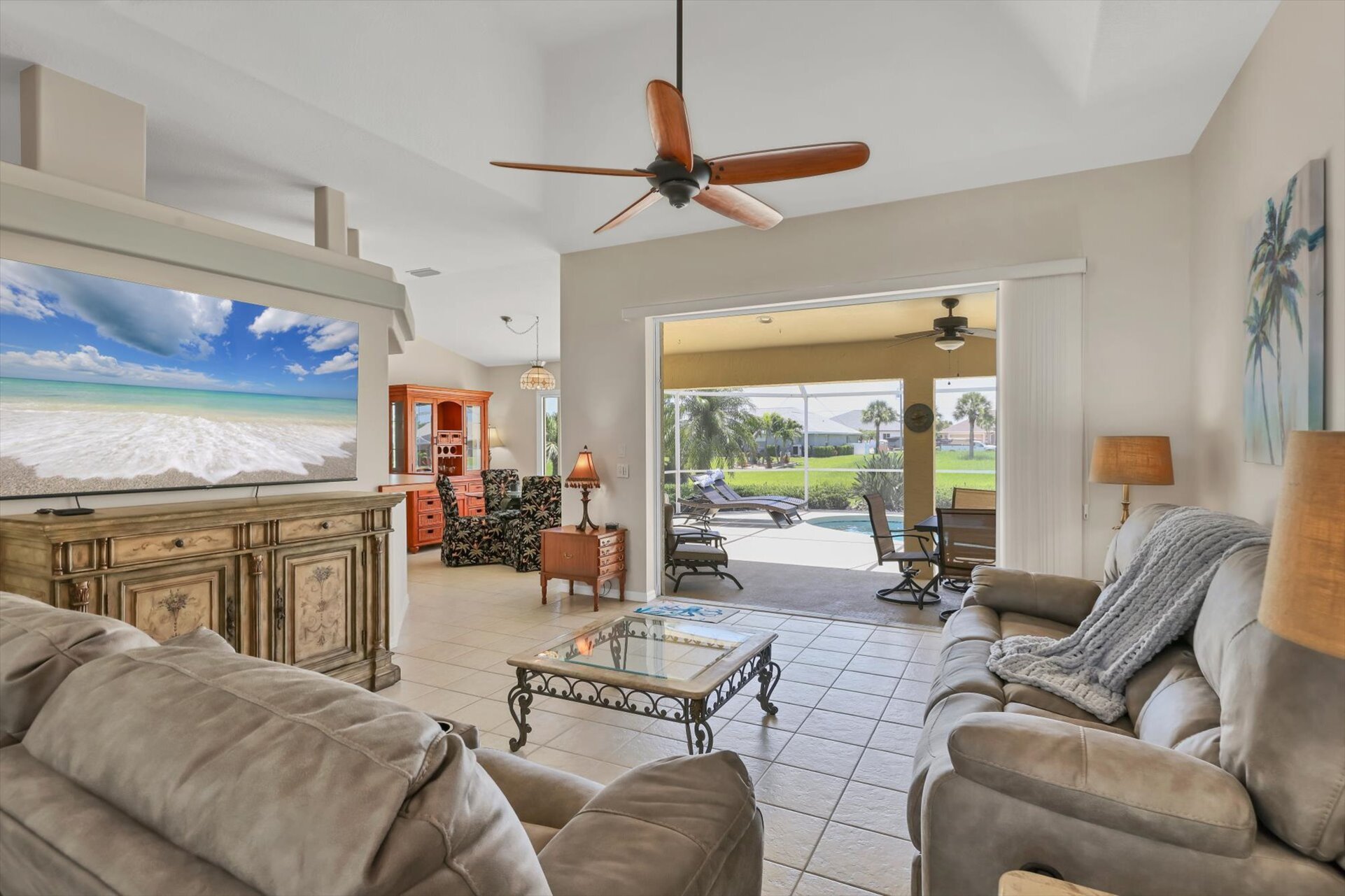 Living room overlooking pool. Living room features plenty of comfy seating and 75-inch Smart TV