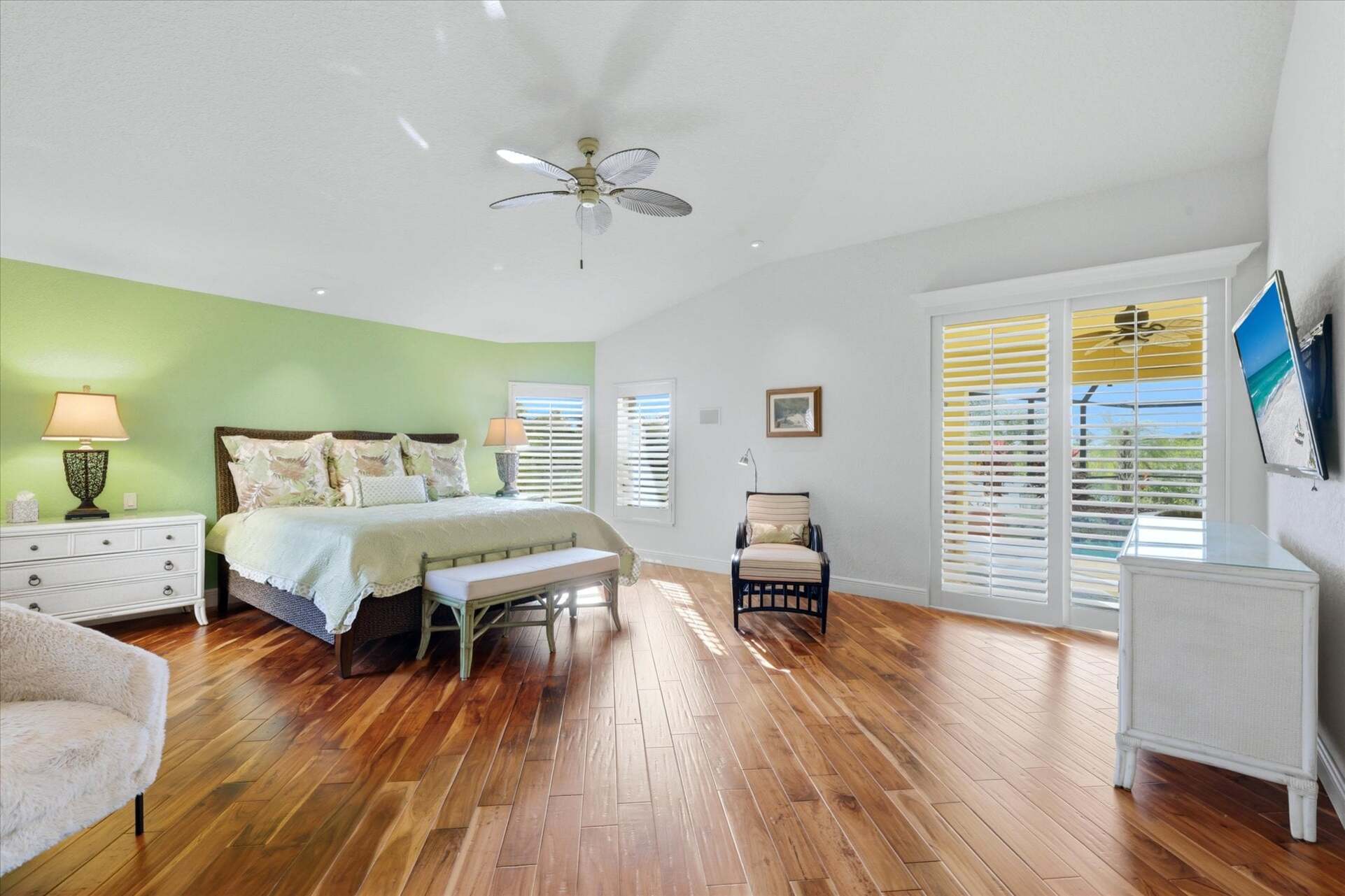 Huge primary bedroom with king bed, lanai acces, attached bathroom, desk & chair, and 55-inch Smart TV