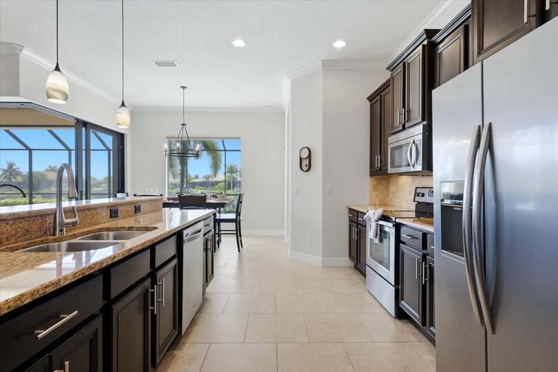 Fully-equipped kitchen overlooking the living room and dining areas. The kitchen features lots of countertop & storage space, and stainless-steel appliances. Kitchen island seats 4