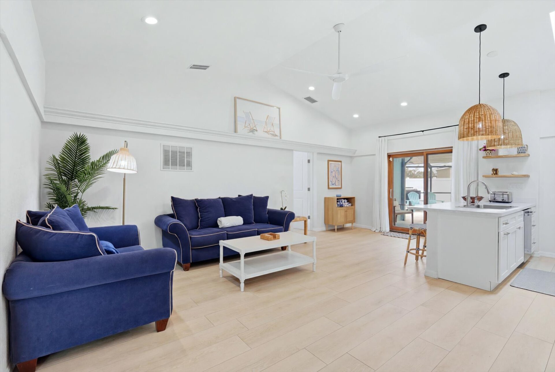 Bright, open living space with comfy seating, 75-inch Smart TV, and lanai access
